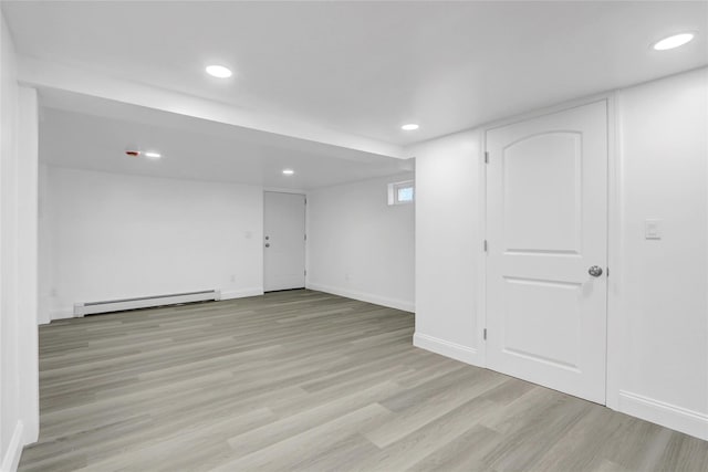 10 Branch Pl, Roosevelt, NY 11575 - finished below grade area featuring a baseboard heating unit, light wood finished floors, and recessed lighting