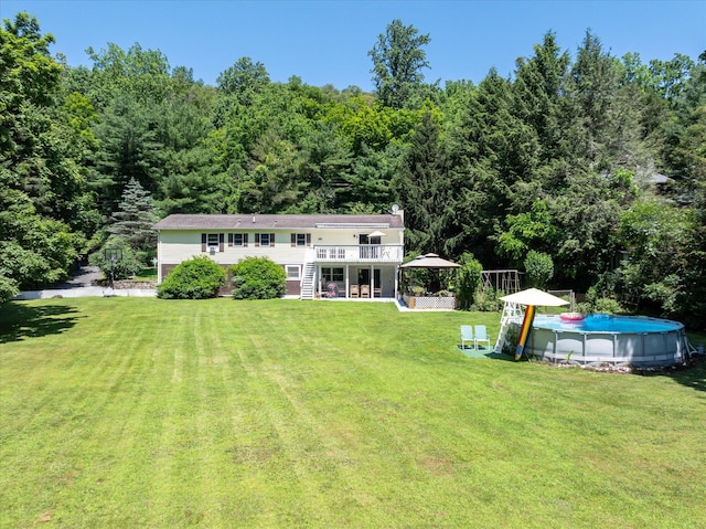 542 Peekskill Hollow Rd, Putnam Valley, NY 10579 - rear view of property with stairs, a wooden deck, a lawn, a forest view, and an outdoor pool