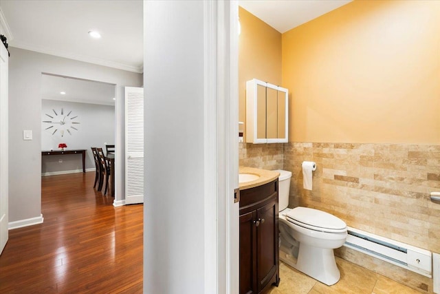 346 Richard Ct, Pomona, NY 10970 - half bathroom featuring a baseboard radiator, tile walls, vanity, ornamental molding, and wood finished floors