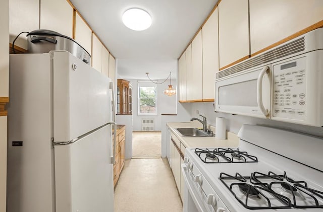 46-01 39th Ave Unit 106, Woodside, NY 11104 - kitchen with white appliances, radiator heating unit, and light countertops