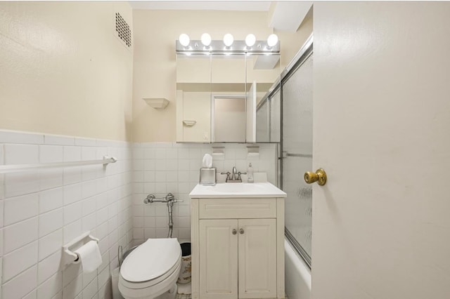 46-01 39th Ave Unit 106, Woodside, NY 11104 - bathroom featuring vanity, enclosed tub / shower combo, and tile walls
