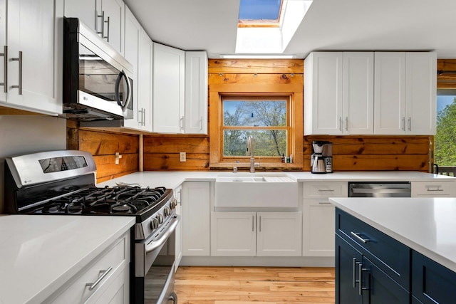 354 Sunset Hill Rd E, Fishkill, NY 12524 - kitchen featuring stainless steel appliances, a skylight, white cabinets, and light countertops