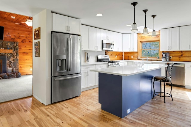 354 Sunset Hill Rd E, Fishkill, NY 12524 - kitchen featuring stainless steel appliances, light wood-style flooring, white cabinetry, light countertops, and a breakfast bar