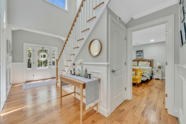 206 Brooksite Dr, Smithtown, NY 11787 - entrance foyer featuring stairway, light wood-style flooring, a wainscoted wall, ornamental molding, and a decorative wall