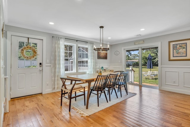 206 Brooksite Dr, Smithtown, NY 11787 - dining area featuring crown molding, a decorative wall, a chandelier, wainscoting, and light wood-style floors