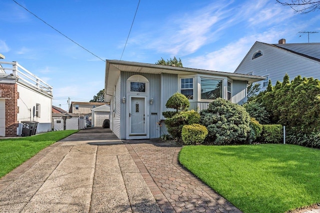 46 Pine St, Oceanside, NY 11572 - view of front of property featuring a front lawn, a detached garage, and an outbuilding