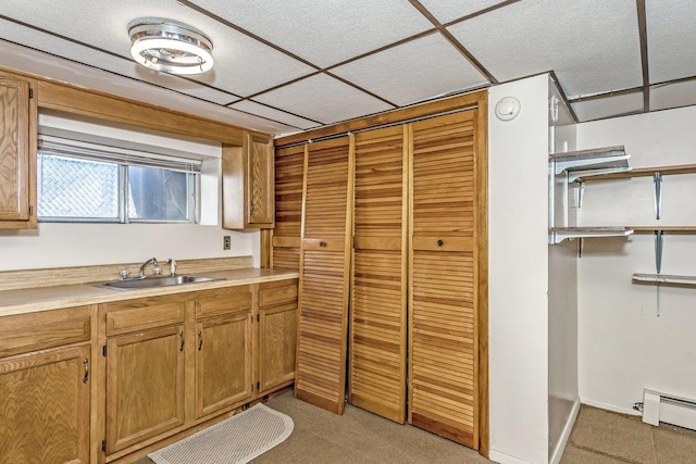 46 Pine St, Oceanside, NY 11572 - kitchen with a baseboard radiator, light colored carpet, light countertops, and brown cabinetry