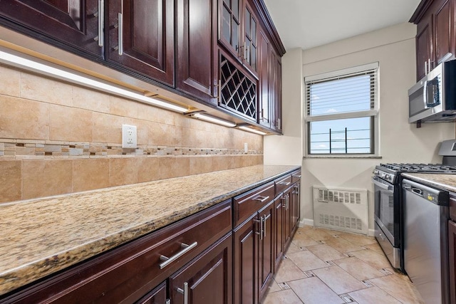 99-72 66th Rd Unit 9B, Rego Park, NY 11374 - kitchen featuring stainless steel appliances, backsplash, light stone countertops, and dark brown cabinetry