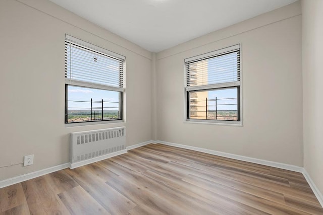 99-72 66th Rd Unit 9B, Rego Park, NY 11374 - unfurnished room featuring radiator, plenty of natural light, and light wood-style floors