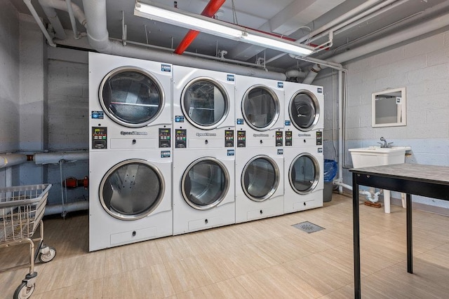 99-72 66th Rd Unit 9B, Rego Park, NY 11374 - shared laundry featuring stacked washing machine and dryer, washer and clothes dryer, and concrete block wall