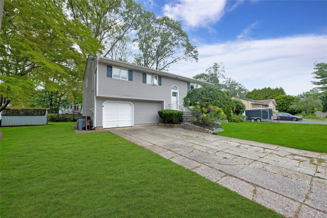 26 Shenandoah Blvd, Port Jefferson Station, NY 11776 - split foyer home with concrete driveway, a garage, and a front lawn