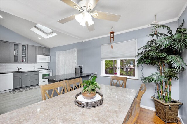 26 Shenandoah Blvd, Port Jefferson Station, NY 11776 - dining area featuring light wood-style floors, a skylight, a ceiling fan, and vaulted ceiling