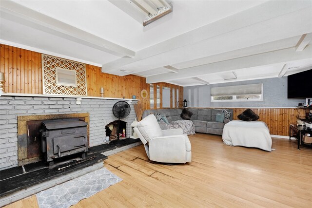 26 Shenandoah Blvd, Port Jefferson Station, NY 11776 - living room with wooden walls, wood finished floors, beam ceiling, and a wood stove