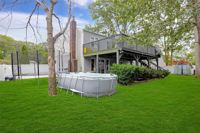 26 Shenandoah Blvd, Port Jefferson Station, NY 11776 - rear view of property featuring a deck, a storage unit, an outdoor pool, a chimney, and a trampoline