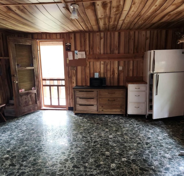 7219 State Rte 42, Grahamsville, NY 12740 - kitchen with freestanding refrigerator, wooden ceiling, dark countertops, wooden walls, and black microwave