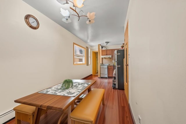 1314 College Point Blvd, College Point, NY 11356 - dining space with a baseboard heating unit, a chandelier, and wood finished floors