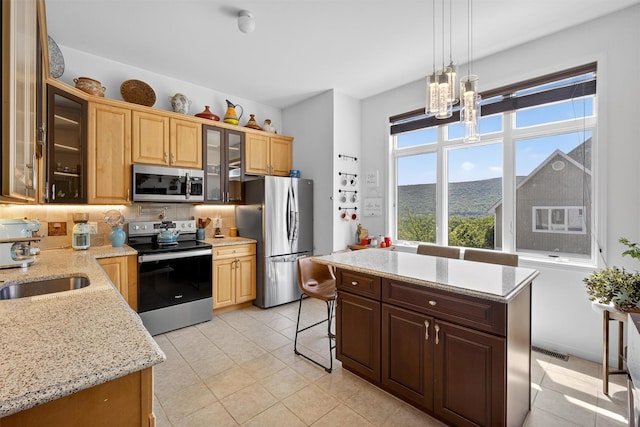 50 Corbin Hill Rd Unit 13, Fort Montgomery, NY 10922 - kitchen with stainless steel appliances, light tile patterned floors, pendant lighting, a chandelier, and light stone countertops