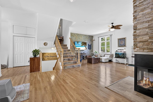 50 Corbin Hill Rd Unit 13, Fort Montgomery, NY 10922 - living room featuring a stone fireplace, a ceiling fan, wood finished floors, and stairs