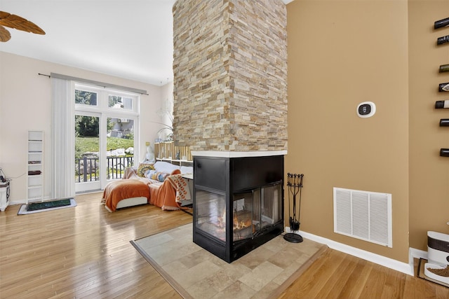 50 Corbin Hill Rd Unit 13, Fort Montgomery, NY 10922 - living room with a towering ceiling, light wood-style flooring, and a stone fireplace