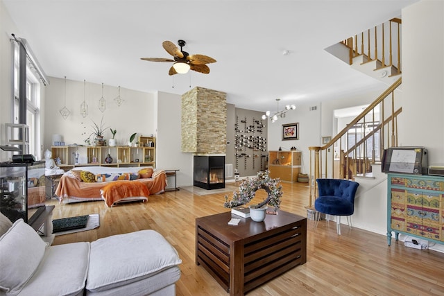 50 Corbin Hill Rd Unit 13, Fort Montgomery, NY 10922 - living room featuring stairway, light wood finished floors, ceiling fan, a stone fireplace, and a chandelier