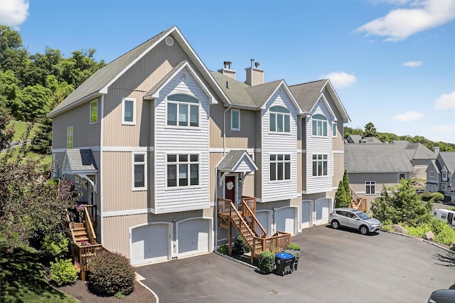 50 Corbin Hill Rd Unit 13, Fort Montgomery, NY 10922 - view of property featuring driveway, a garage, a chimney, and roof with shingles