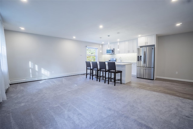 460 Old Town Rd Unit 4-O, Port Jefferson Station, NY 11776 - kitchen with appliances with stainless steel finishes, recessed lighting, white cabinets, a center island with sink, and light carpet