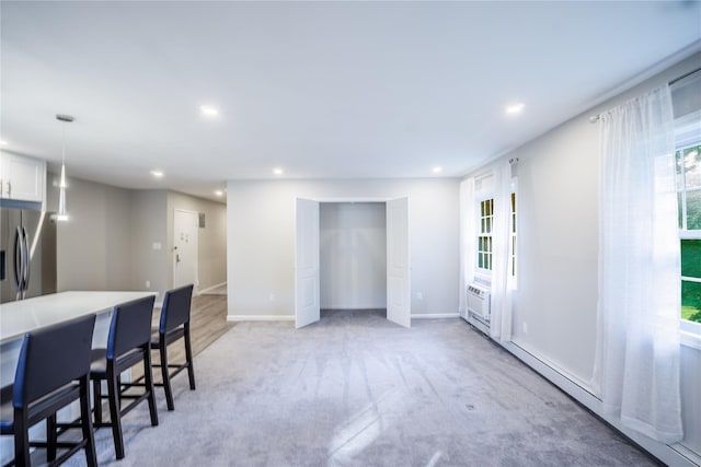 460 Old Town Rd Unit 4-O, Port Jefferson Station, NY 11776 - kitchen featuring stainless steel refrigerator with ice dispenser, a kitchen bar, plenty of natural light, recessed lighting, and white cabinetry