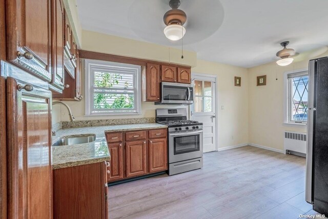 216 Raff Ave, Mineola, NY 11501 - kitchen with appliances with stainless steel finishes, ceiling fan, radiator, and plenty of natural light