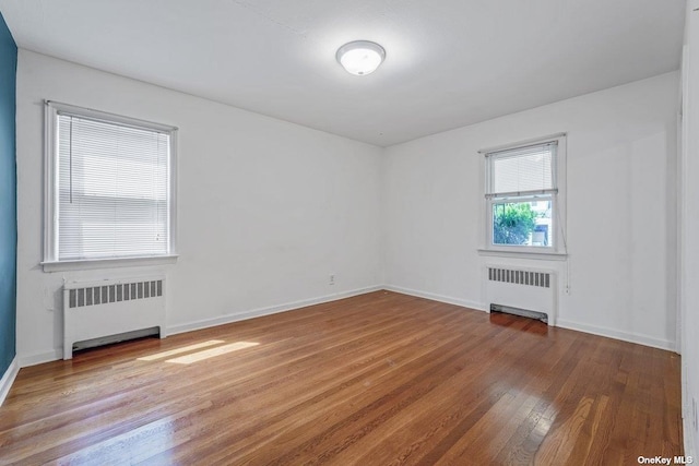 216 Raff Ave, Mineola, NY 11501 - spare room featuring radiator and wood finished floors