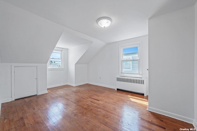 216 Raff Ave, Mineola, NY 11501 - additional living space with radiator heating unit, healthy amount of natural light, wood finished floors, and lofted ceiling