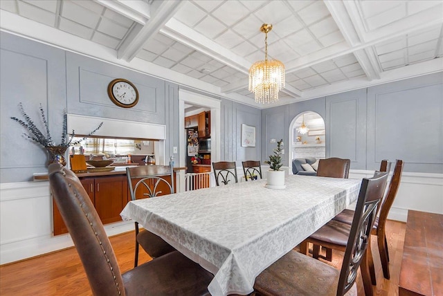 7 Wellesley Ave, Yonkers, NY 10705 - dining area with a decorative wall, a chandelier, light wood-style floors, coffered ceiling, and beam ceiling