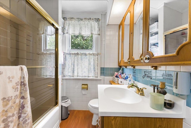 7 Wellesley Ave, Yonkers, NY 10705 - full bathroom with tile walls, vanity, wood finished floors, shower / bath combination with glass door, and ornamental molding