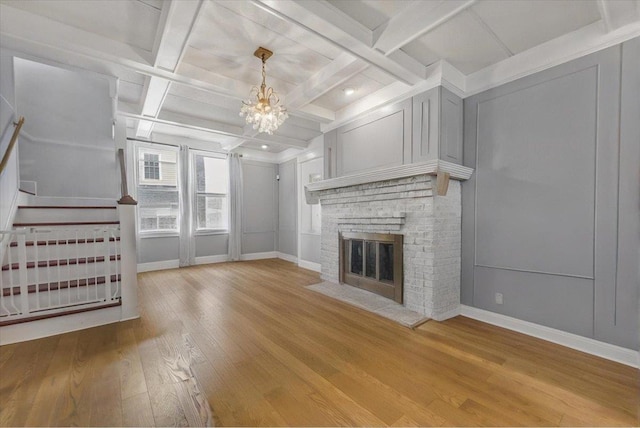 7 Wellesley Ave, Yonkers, NY 10705 - unfurnished living room with wood finished floors, coffered ceiling, a chandelier, a fireplace, and stairway