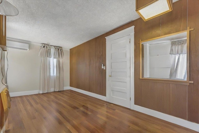 7 Wellesley Ave, Yonkers, NY 10705 - entrance foyer featuring a wall mounted air conditioner, wood finished floors, wooden walls, and a textured ceiling