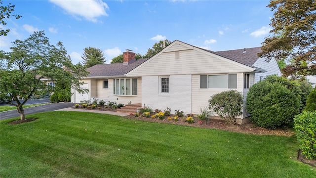 1942 Lilac Dr, Westbury, NY 11590 - ranch-style home featuring a garage, asphalt driveway, a chimney, a front lawn, and a shingled roof
