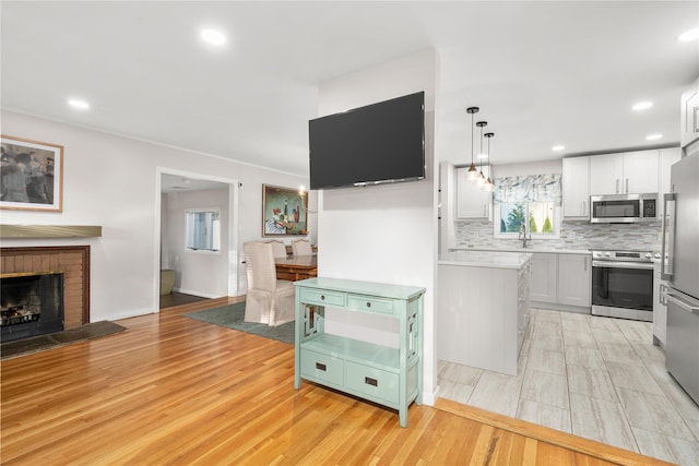 1942 Lilac Dr, Westbury, NY 11590 - kitchen featuring appliances with stainless steel finishes, backsplash, light wood-style floors, light countertops, and recessed lighting
