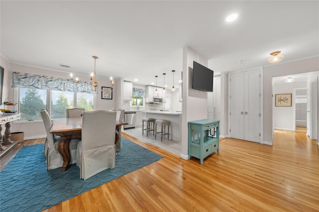 1942 Lilac Dr, Westbury, NY 11590 - dining space featuring light wood-type flooring, recessed lighting, and a chandelier