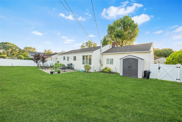 1942 Lilac Dr, Westbury, NY 11590 - back of property with a gate, a patio area, a fenced backyard, a storage shed, and a chimney
