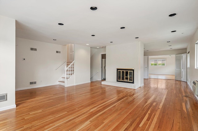 1901 New Hyde Park Rd, New Hyde Park, NY 11040 - unfurnished living room featuring light wood finished floors, stairs, a fireplace, and recessed lighting
