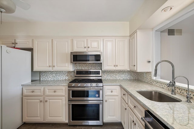 1901 New Hyde Park Rd, New Hyde Park, NY 11040 - kitchen featuring stainless steel appliances, light stone counters, backsplash, and a ceiling fan