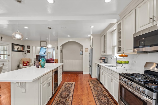 194 Valentine St, Yonkers, NY 10704 - kitchen with stainless steel appliances, wine cooler, arched walkways, wood finished floors, and light countertops