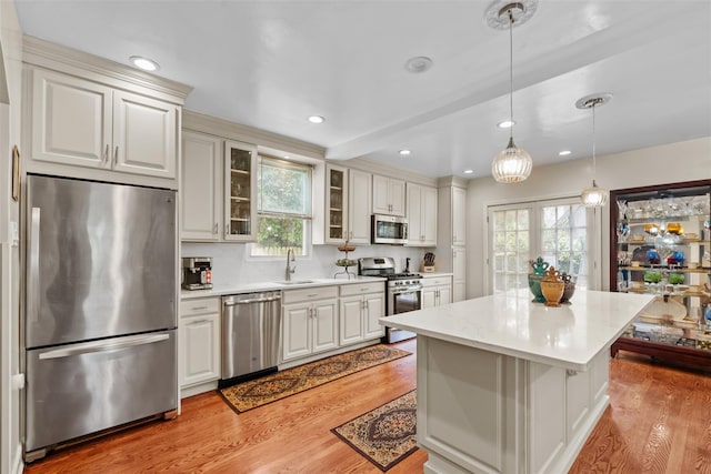 194 Valentine St, Yonkers, NY 10704 - kitchen with stainless steel appliances, light wood-type flooring, glass insert cabinets, decorative light fixtures, and recessed lighting
