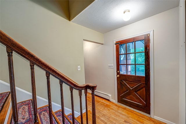 10 Valentine Rd, Shoreham, NY 11786 - entrance foyer with a baseboard radiator, light wood-type flooring, stairway, and a textured ceiling