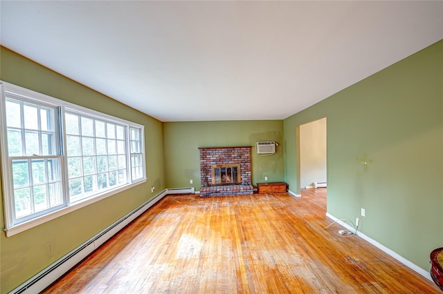 10 Valentine Rd, Shoreham, NY 11786 - unfurnished living room featuring a baseboard heating unit, light wood-type flooring, a fireplace, and a wall mounted air conditioner