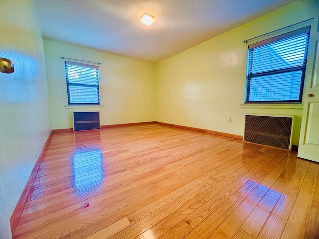 196-58 69th Ave Unit 1, Fresh Meadows, NY 11365 - empty room with light wood-style floors, radiator, and a fireplace