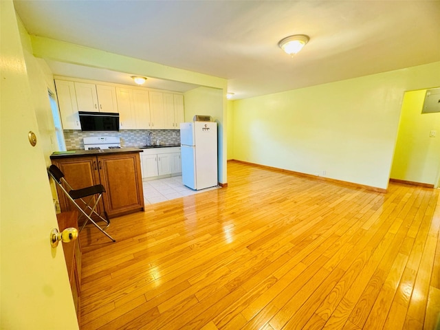 196-58 69th Ave Unit 1, Fresh Meadows, NY 11365 - kitchen with freestanding refrigerator, dark countertops, range, and light wood-style floors