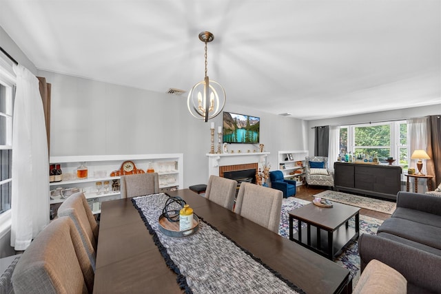 15 Cedar Ln, Cornwall, NY 12518 - dining area with a chandelier, a brick fireplace, and wood finished floors
