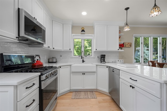 54 Bankside Dr, Centerport, NY 11721 - kitchen with appliances with stainless steel finishes, a peninsula, crown molding, white cabinets, and tasteful backsplash