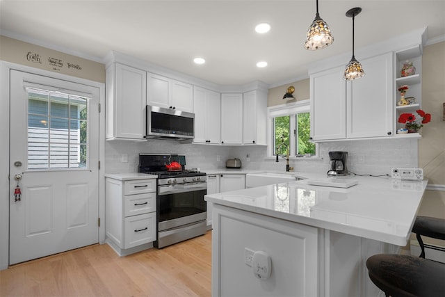 54 Bankside Dr, Centerport, NY 11721 - kitchen with stainless steel appliances, a peninsula, white cabinetry, a breakfast bar, and backsplash