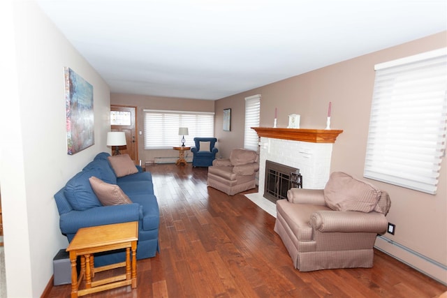 66 Parma Rd, Island Park, NY 11558 - living room with a baseboard heating unit, wood finished floors, and a brick fireplace